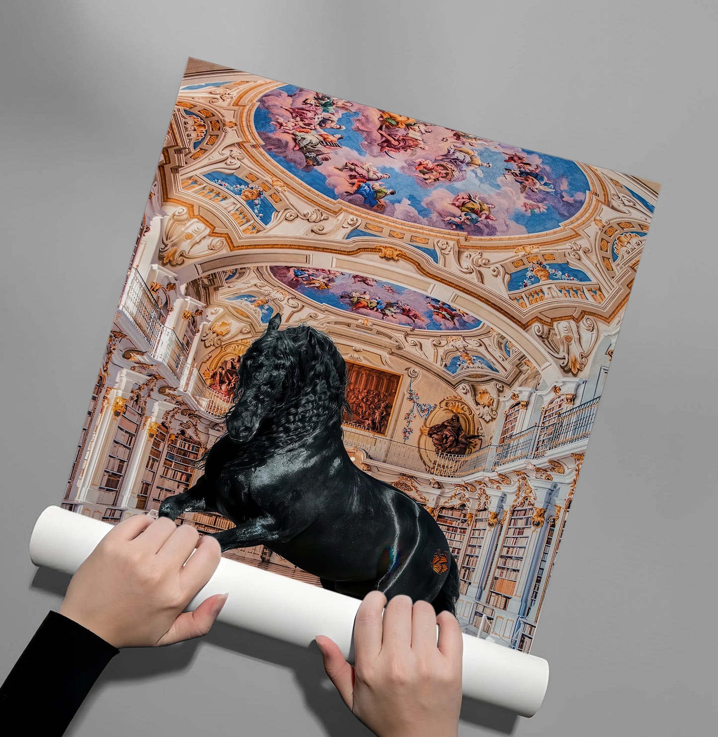 2Hands unrolling a glossy poster print of a black horse rearing up in an ornate gold palace library.