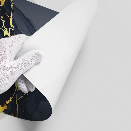 Hand in white glove peeling backing from dark navy blue and gold abstract poster wall decal UAE Dubai.