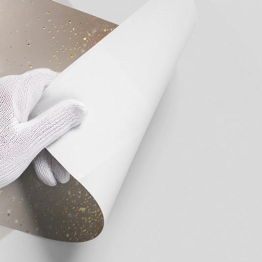 Hand in white glove peeling backing from gold glitter ombre poster wall decal UAE Dubai.