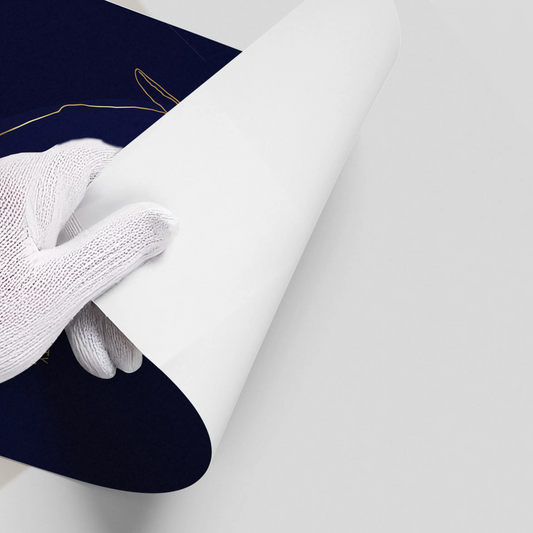 Close-up of white gloved hand peeling back the corner of a navy blue poster.