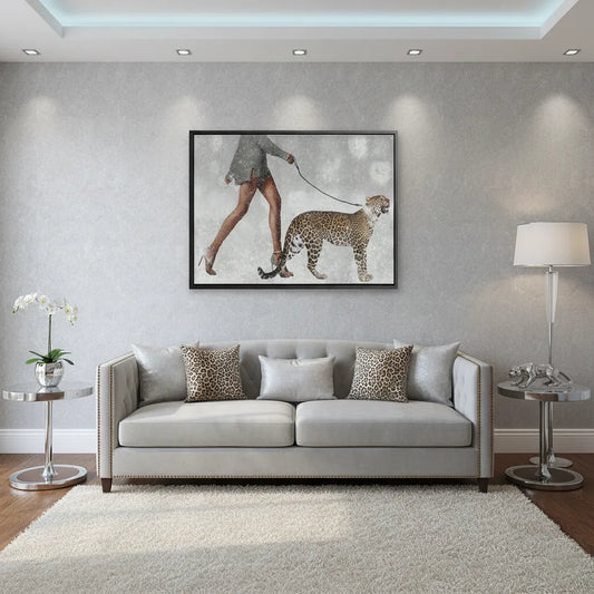 Framed Canvas wall art of woman and leopard hanging above a beige sofa in a modern, bright living room