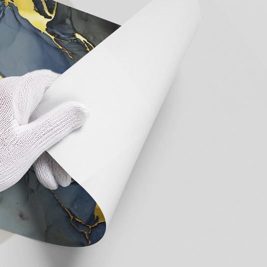 Hand in white glove peeling backing from grey, navy blue, and gold abstract poster wall decal UAE Dubai.