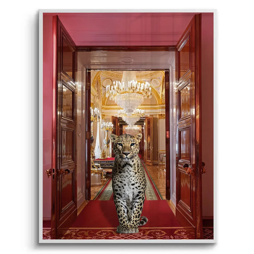 Fine art print of a leopard sitting on a red carpet in a red and gold palace doorway, white frame.