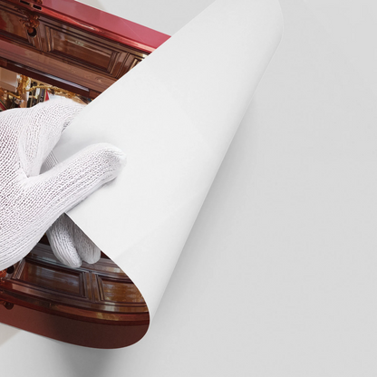 Close-up of a hand in a white glove peeling back the edge of a glossy leopard in palace poster.