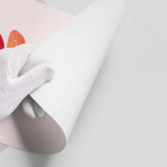 Close-up of a hand in a white glove peeling back the corner of the 'Balance, Baby' flamingo poster.
