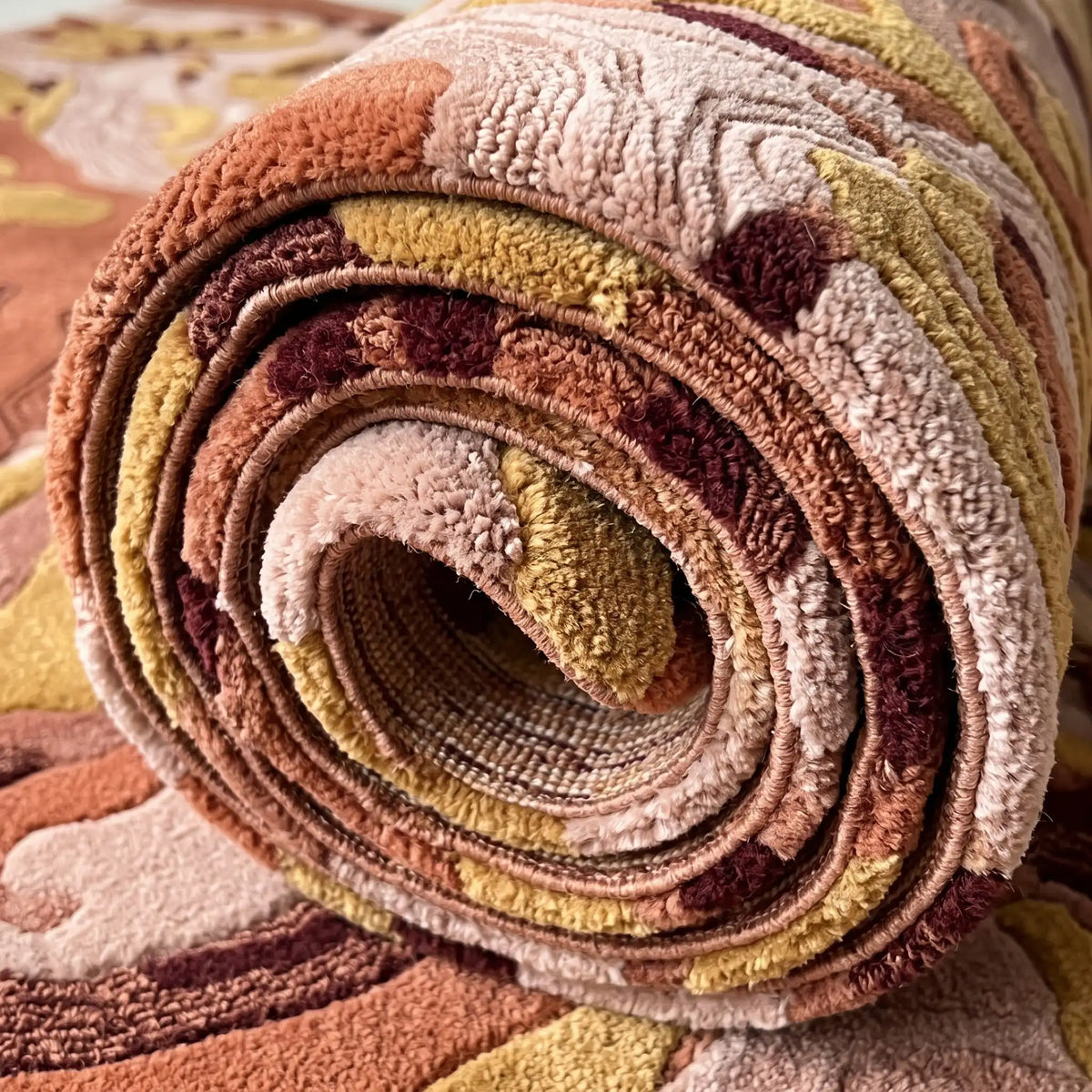 Terrain Bloom modern abstract rug in Saffron Rose – rolled to show the backing and thickness