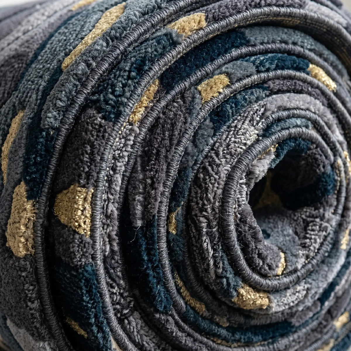 Terrain Bloom modern abstract rug in Midnight Gold – rolled to show the backing and thickness
