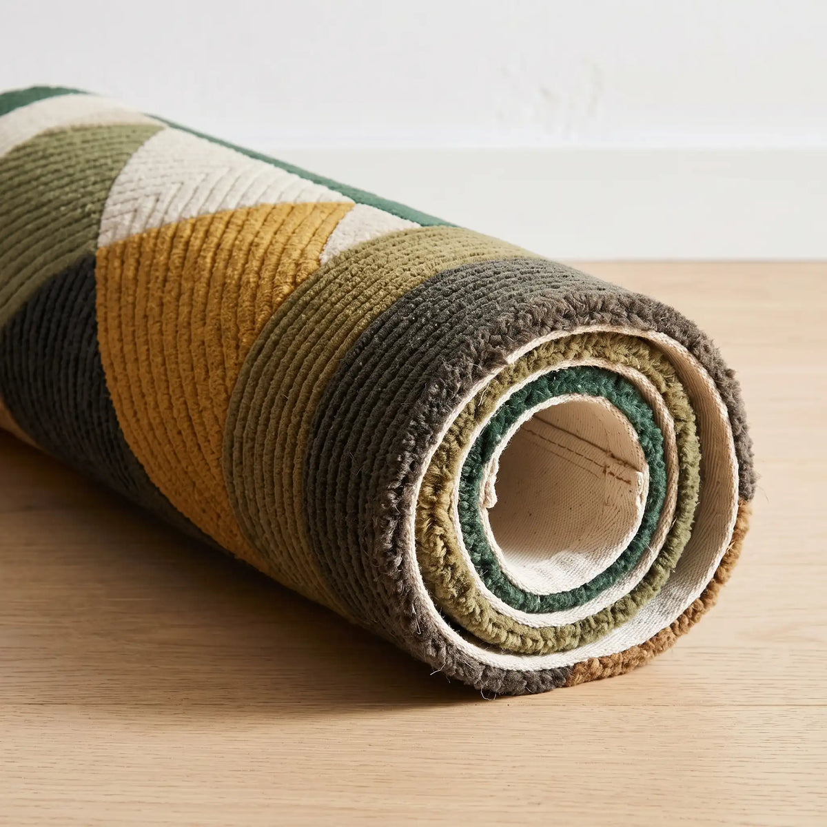 Meridian modern abstract rug in Forest Ochre – rolled to show the backing and thickness