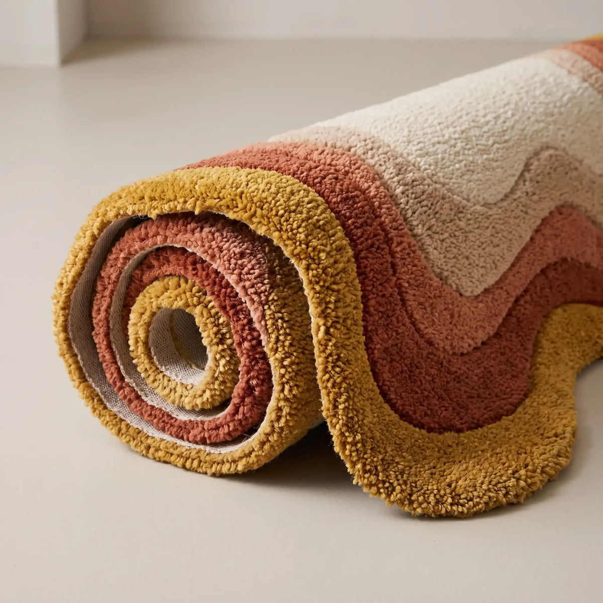 Echo Pool modern abstract rug in Saffron Peach – rolled to show the backing and thickness