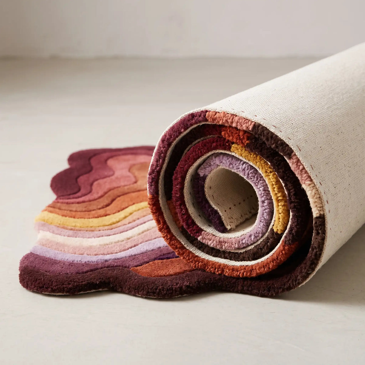 Canyon Waves modern abstract rug in Burgundy Spice – rolled to show the backing and thickness